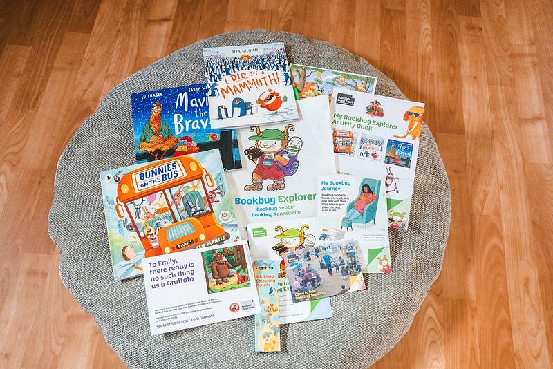 Contents of the Bookbug Explorer Bag 2024 spread out on a cushion